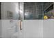 A close-up of a modern shower showcasing dark tile accents, glass doors, and brass hardware at 1402 W Lakewood Ave, Durham, NC 27707