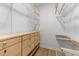 Walk-in closet with wooden shelving, drawers, and hanging rods for organized storage at 141 Hilda Grace Ln, Cary, NC 27519