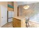 Kitchen featuring wooden cabinets, a center island, stainless steel refrigerator, and stylish wallpaper at 141 Hilda Grace Ln, Cary, NC 27519