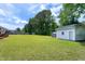 Spacious backyard with a large lawn, storage shed, and a peaceful setting surrounded by mature trees at 141 Montesino Dr, Raleigh, NC 27603