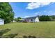 Expansive backyard view showing the house, deck, carport, and lush greenery at 141 Montesino Dr, Raleigh, NC 27603