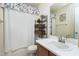 Well-lit bathroom featuring a vanity, mirror, toilet, and shower with a floral-themed shower curtain at 141 Montesino Dr, Raleigh, NC 27603