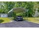 Practical carport featuring covered parking, a paved driveway, and a storage shed in a lush, green backyard at 141 Montesino Dr, Raleigh, NC 27603