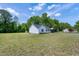 Inviting home exterior with a spacious yard, mature trees, and a covered parking area in a serene setting at 141 Montesino Dr, Raleigh, NC 27603