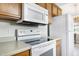 Well-lit kitchen featuring white appliances, wood cabinetry, and functional design for easy meal preparation and cleanup at 141 Montesino Dr, Raleigh, NC 27603