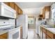 Efficient kitchen with wood cabinets, white appliances, and adjacent dining nook with natural light from the backyard at 141 Montesino Dr, Raleigh, NC 27603