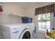 Functional laundry room equipped with a washer, dryer, shelving, and a bright window for natural light at 141 Montesino Dr, Raleigh, NC 27603