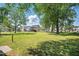 Spacious backyard featuring mature trees, a lush lawn, and other homes in the distance at 1429 Raybon Dr, Wendell, NC 27591