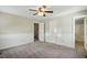 Bedroom with carpet flooring, ceiling fan, and doors leading to the bathroom and hallway at 1429 Raybon Dr, Wendell, NC 27591