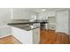 Bright kitchen featuring white cabinets, granite countertops, stainless steel appliances, and hardwood floors at 1429 Raybon Dr, Wendell, NC 27591