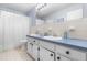 Blue and white bathroom featuring dual sinks, vintage-style flooring, and updated fixtures at 149 Baldwin Dr, Durham, NC 27712