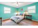 Bright bedroom showcasing teal walls, hardwood floors, and a cozy bed between matching side tables with lamps at 149 Baldwin Dr, Durham, NC 27712