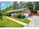 Brick home boasts solar panels, an attached garage, manicured shrubs, and a well-kept green lawn at 149 Baldwin Dr, Durham, NC 27712