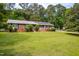 Ranch style home with brick facade, solar panels, manicured bushes, and a green lawn at 149 Baldwin Dr, Durham, NC 27712