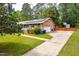 Beautiful brick home with solar panels, attached garage, manicured shrubs, and a lush green lawn at 149 Baldwin Dr, Durham, NC 27712