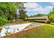 Backyard view of an in-ground pool needing repair, surrounded by mature trees and the house at 149 Baldwin Dr, Durham, NC 27712