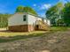 Backyard view featuring a deck with wood stairs and brick foundation at 1622 Julian Oakley Rd, Rougemont, NC 27572