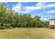 Lush backyard featuring mature trees, a neatly mowed lawn, and a view of the home's siding at 1811 Sandoval Dr, Durham, NC 27703