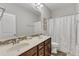 Well-lit bathroom featuring a double vanity, a framed mirror, and a shower with a curtain at 1811 Sandoval Dr, Durham, NC 27703