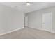 Empty bedroom featuring neutral paint, carpet, a ceiling light, a door, and an attic access panel at 1811 Sandoval Dr, Durham, NC 27703