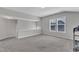 Bonus room space with neutral carpet and paint, natural light, and access to upper level at 1811 Sandoval Dr, Durham, NC 27703