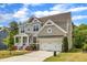 Attractive two-story home featuring a lush green lawn, colorful flower beds, and an attached two-car garage at 1811 Sandoval Dr, Durham, NC 27703