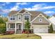 Charming two-story home featuring a manicured lawn, stone accents, and a two-car garage at 1811 Sandoval Dr, Durham, NC 27703