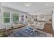 Sun-filled living room with hardwood floors, lots of seating, and view into the kitchen at 1811 Sandoval Dr, Durham, NC 27703