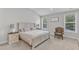 Bright main bedroom with a comfortable bed, bedside tables, lamps, and natural light from two windows at 1811 Sandoval Dr, Durham, NC 27703