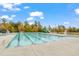 Bright outdoor swimming pool with slide, lane markers, and various seating areas, surrounded by a fence and landscaping at 1811 Sandoval Dr, Durham, NC 27703