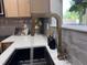 Close up of the sink with a modern faucet, quartz countertops, and gray backsplash at 1820 Collier Rd, Durham, NC 27707
