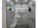 Modern tiled shower with glass door, rainfall shower head, and built in seat and shelving at 1820 Collier Rd, Durham, NC 27707