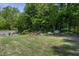 Large backyard featuring lush landscaping, a stone patio and retaining wall, perfect for outdoor living and entertaining at 199 Telluride Trl, Garner, NC 27529