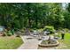 Landscaped backyard area with brick patio and furniture surrounded by lush greenery at 199 Telluride Trl, Garner, NC 27529