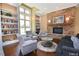 Cozy living room with built-in bookshelves, a stone fireplace, and large windows, creating a warm and inviting atmosphere at 199 Telluride Trl, Garner, NC 27529