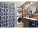 Bathroom featuring a stackable washer and dryer, wood accent wall and custom sink at 2005 Chalybeate Springs Rd, Fuquay Varina, NC 27526