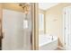 Bathroom features white cabinets, separate bathtub, and glass-door shower at 225 Gulley Glen Dr, Garner, NC 27529