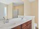 Bathroom features dual sinks, dark brown cabinets, and shower with glass doors at 225 Gulley Glen Dr, Garner, NC 27529