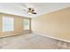 Large bedroom with carpet, ceiling fan, and multiple windows at 225 Gulley Glen Dr, Garner, NC 27529