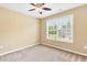 Carpeted bedroom offers natural light through a window and is complete with a ceiling fan at 225 Gulley Glen Dr, Garner, NC 27529