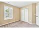 Cozy bedroom features neutral walls, plush carpeting, a window with natural light, and a closet for storage at 225 Gulley Glen Dr, Garner, NC 27529