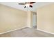 A neutral painted bedroom with carpeted floors, ceiling fan, and closet space at 225 Gulley Glen Dr, Garner, NC 27529