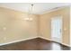 Open dining area featuring hardwood floors, chandelier, and door leading to the exterior at 225 Gulley Glen Dr, Garner, NC 27529