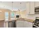 Open kitchen features granite countertops, stainless appliances, white cabinets, and view into the living room at 225 Gulley Glen Dr, Garner, NC 27529