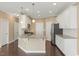 The bright kitchen has white cabinets, granite countertops, stainless appliances, and hardwood floors at 225 Gulley Glen Dr, Garner, NC 27529