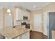 The kitchen has granite countertops, white cabinets, stainless appliances, tile backsplash, and hardwood floors at 225 Gulley Glen Dr, Garner, NC 27529