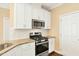 The kitchen features granite countertops, stainless appliances, gas range, tile backsplash, and white cabinets at 225 Gulley Glen Dr, Garner, NC 27529