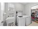 Well-lit laundry room with modern washer and dryer, sink, and plenty of storage shelves for added convenience at 2323 Big Sky Ln, Raleigh, NC 27615