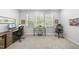 Bright home office featuring three large windows, an ergo chair, and a glass-topped desk for a modern touch at 2323 Big Sky Ln, Raleigh, NC 27615
