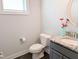 Cozy powder room with granite countertop, vanity, and modern fixtures at 2472 Patriot Bluffs Dr, Fuquay Varina, NC 27526